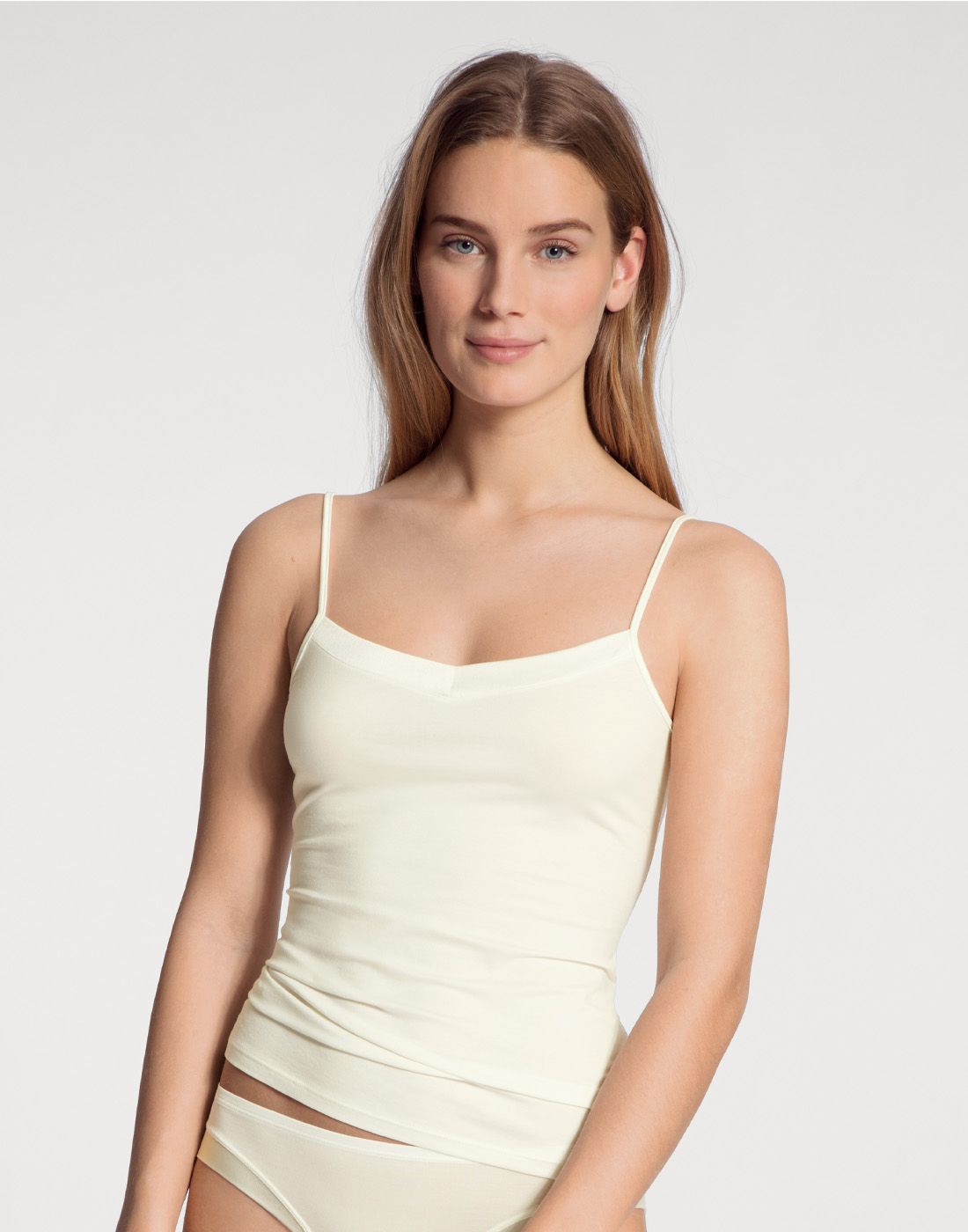 blond kvinne med spaghetti topp i creme farge