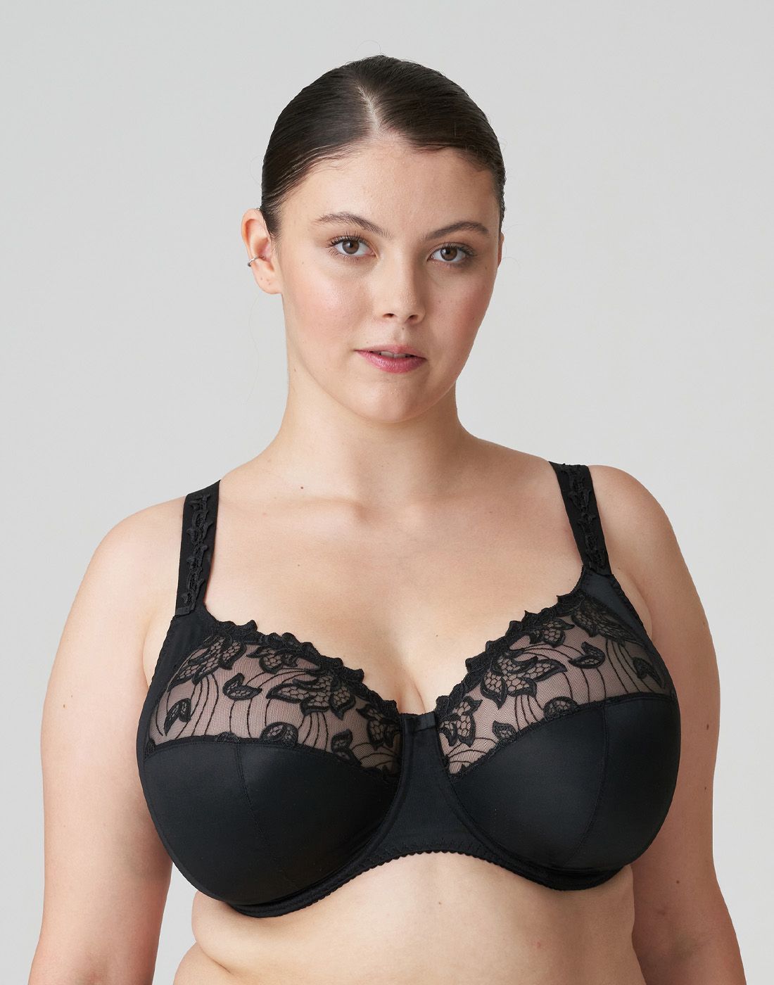 kvinne med stor byste og svart BH i stor cup