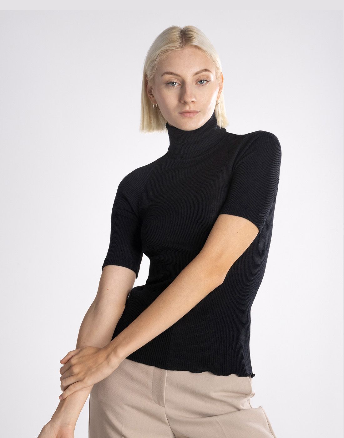 3445-20(1) blond kvinne i svart høyhalset t-skjorte av ull og silke