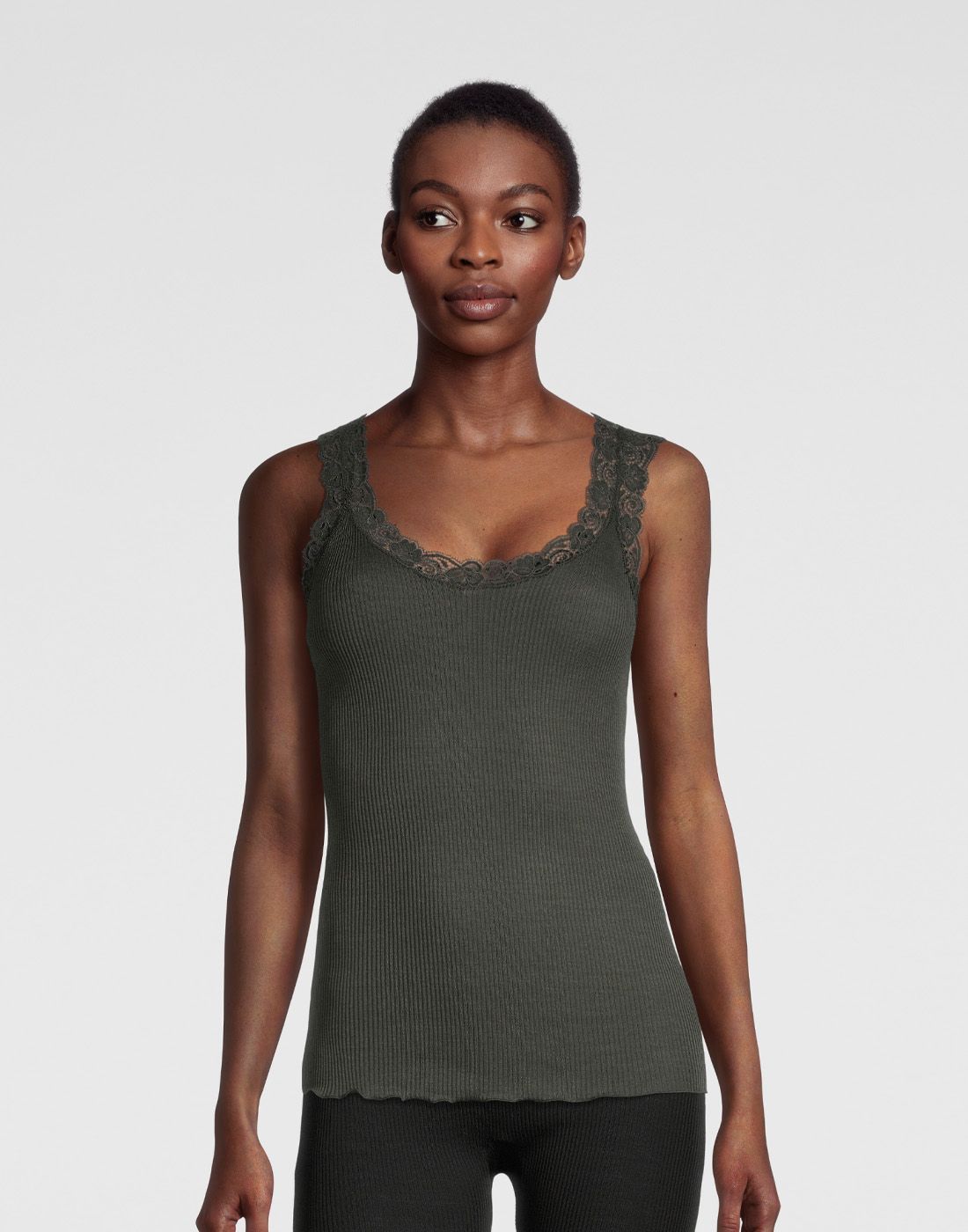 kvinne i mørkegrønn ull og silke singlet med blonde