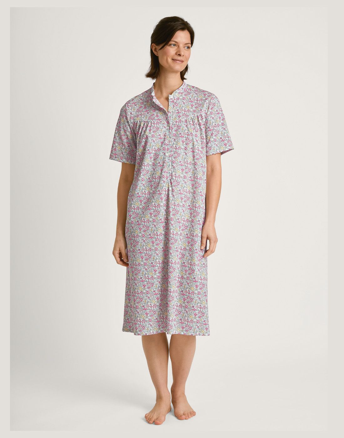 mørk kvinne i lang blomstrete nattkjole i bomull