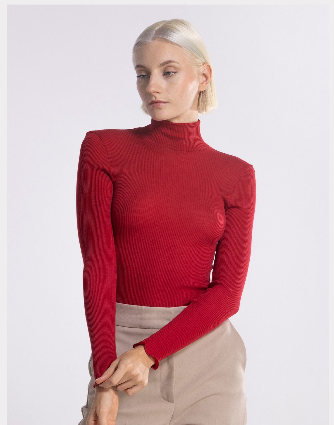 blond kvinne i rød høyhalset genser av ull og silke
