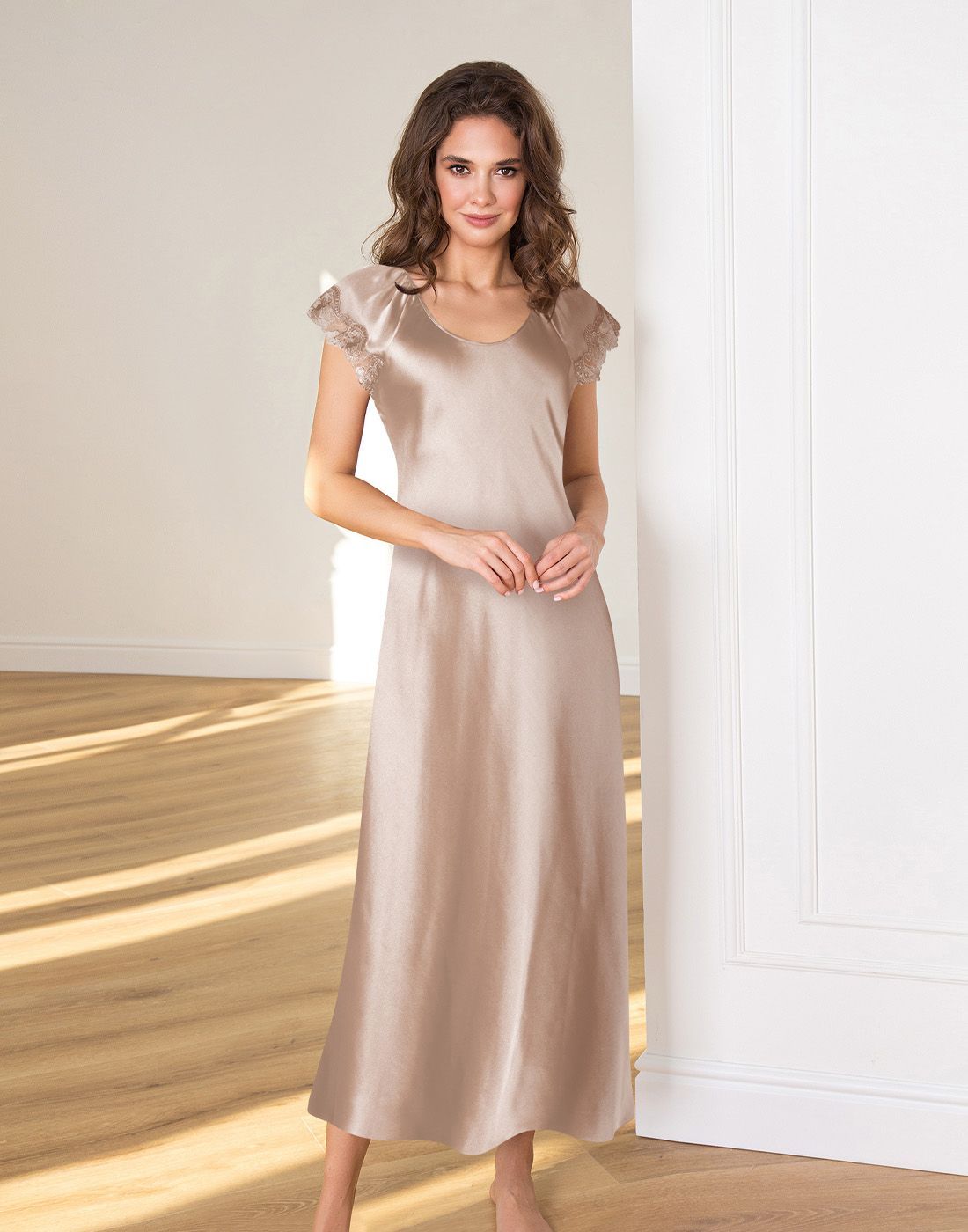 kvinne med brunt hår og lang silke nattkjole med blonder